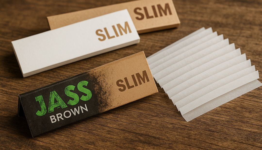 Packs de feuilles slim Jass marron et blanches posés sur une table en bois avec feuilles dépliées en éventail