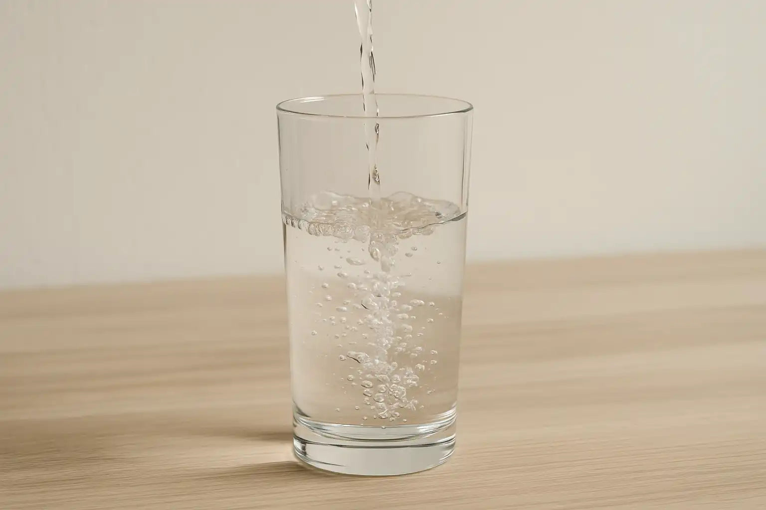 verre d’eau versé sur une table en bois, symbole des fausses croyances de “détox THC par hydratation